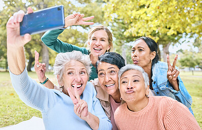 Buy stock photo Senior people, friends and phone for selfie at the park together with smile and peace sign in the outdoors. Happy group of silly elderly women smiling for photo looking at smartphone in nature