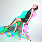 Fashion, chair and woman model in studio with neon color lights or shadow isolated on a white background. Young model person with kaleidoscope style, glitter dress and psychedelic mockup copy space