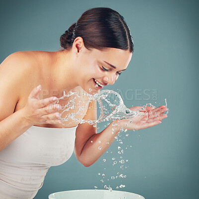 Buy stock photo Water splash, woman and skincare while washing face for dermatology wellness on a studio background. Health and glow of a happy aesthetic model person cleaning skin or body for facial spa treatment