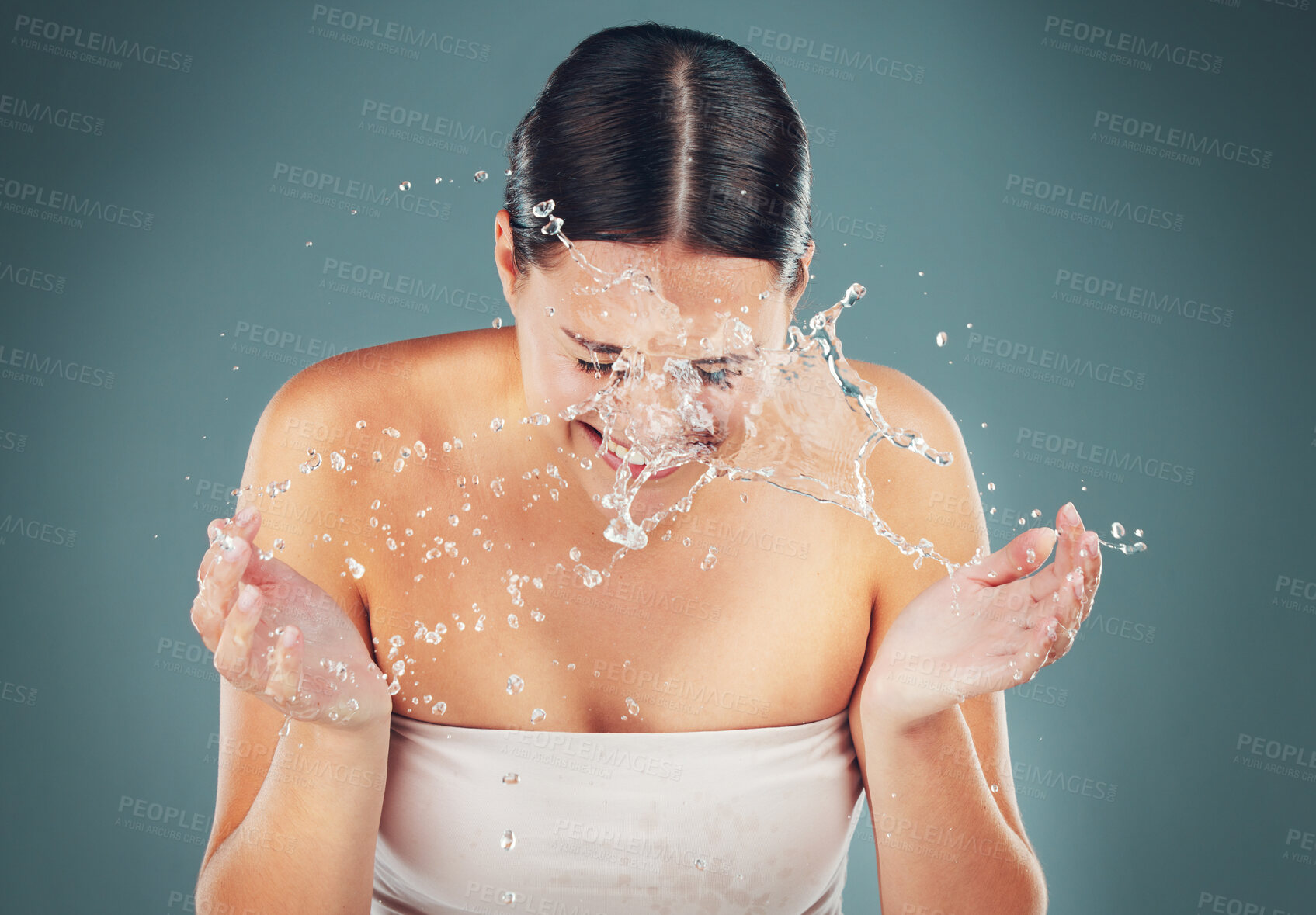 Buy stock photo Beauty, water splash and washing face for skincare, cleaning and dermatology on a studio background. Health and wellness of a aesthetic model person cleaning skin or body for facial spa treatment