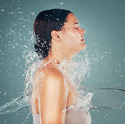 Buy stock photo Shower, wellness and water splash on woman for skincare hygiene and hydration isolated in a studio background. Skin, grooming and dermatology for young beautiful adult doing self care