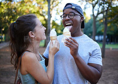 Buy stock photo Interracial, ice cream or couple of friends in a park walking on a fun romantic date in nature bonding together. Romance, relaxed black man and happy woman loves eating a snack on a holiday vacation