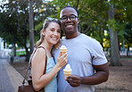 Eating, interracial and portrait of couple with ice cream in a park on a date, anniversary or walk. Love, smile and man and woman with a sweet dessert while walking in nature with romantic affection