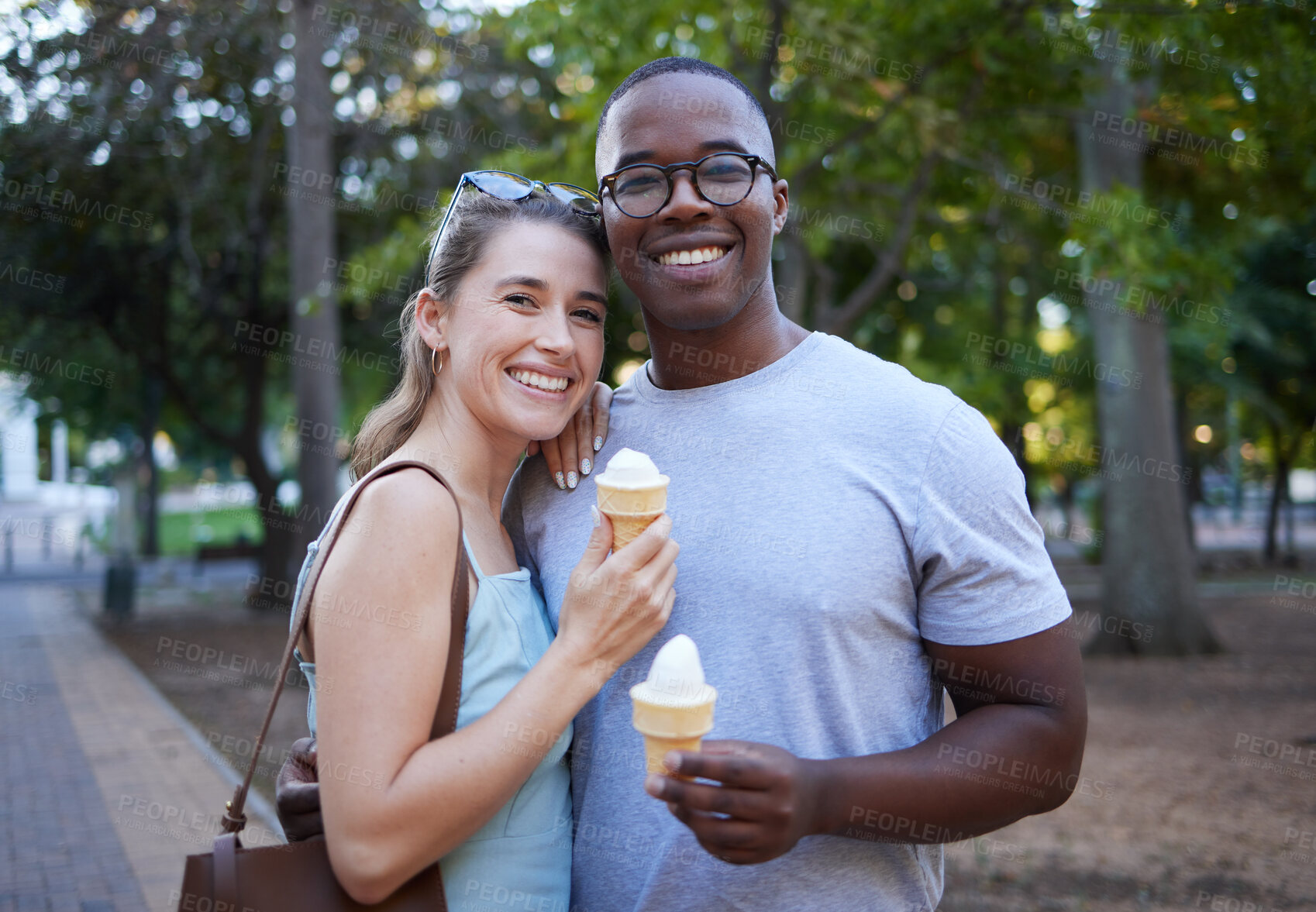 Buy stock photo Eating, interracial and portrait of couple with ice cream in a park on a date, anniversary or walk. Love, smile and man and woman with a sweet dessert while walking in nature with romantic affection