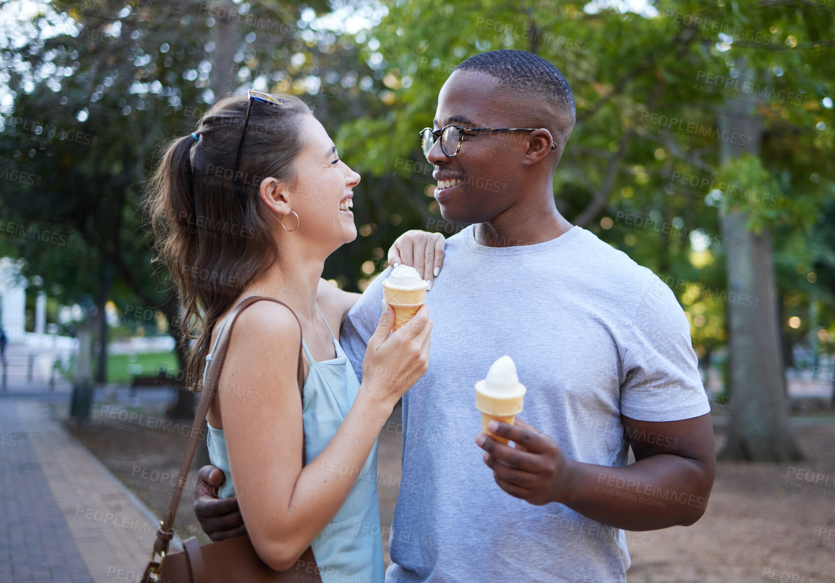 Buy stock photo Love, ice cream or couple of friends hug in a park on a romantic date in nature in an interracial relationship. Bonding, relaxed black man and happy woman enjoying a snack on a fun holiday vacation