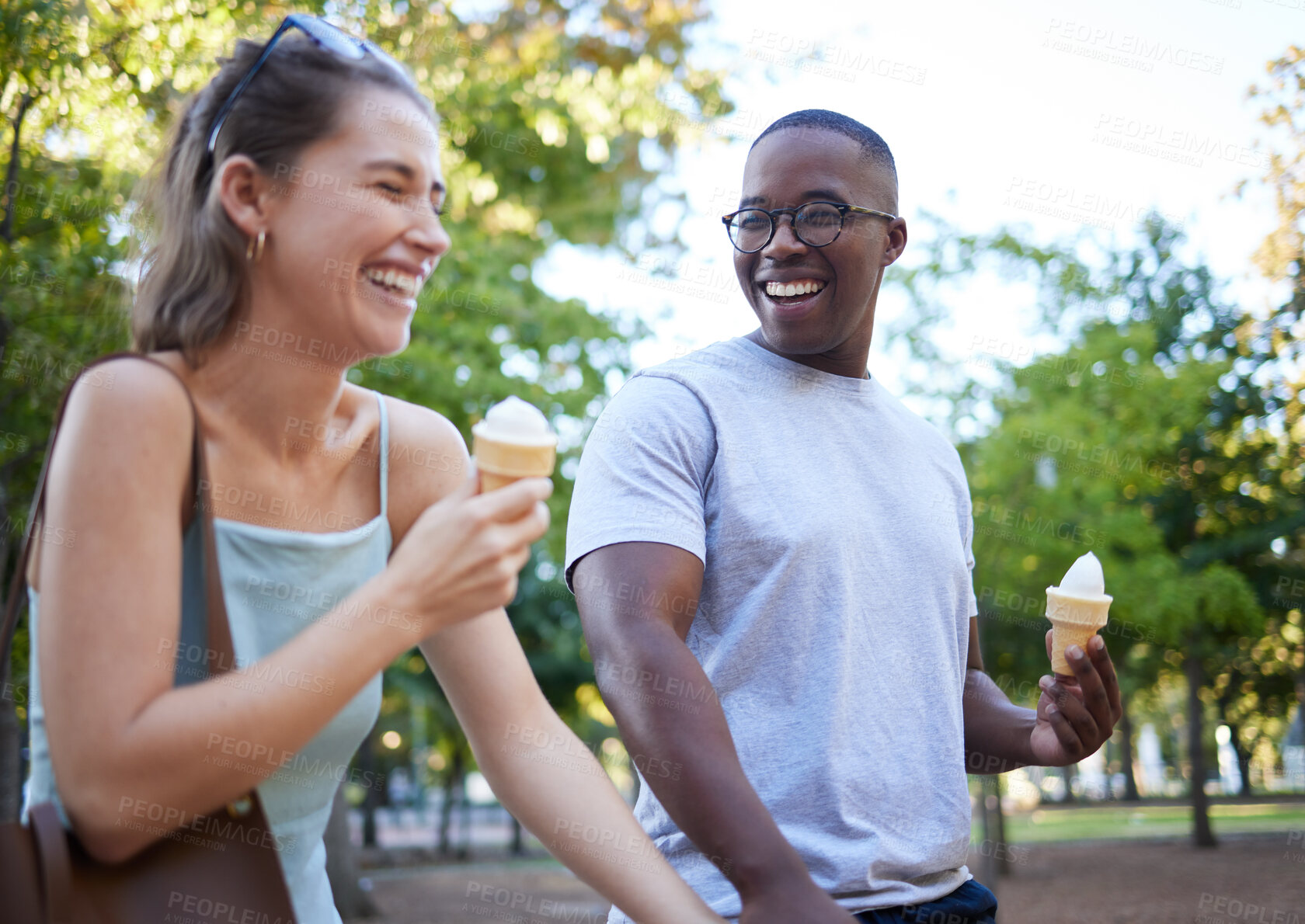 Buy stock photo Interracial couple, laughing and ice cream for funny joke, conversation or bonding together in the park. Happy man and woman sharing laugh with smile for humor, trip or holiday with desert in nature