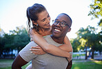 Love, interracial or couple of friends in a park on fun romantic date in nature bonding together. Piggy back, relaxed black man or happy woman laughing or enjoying quality time on a holiday vacation