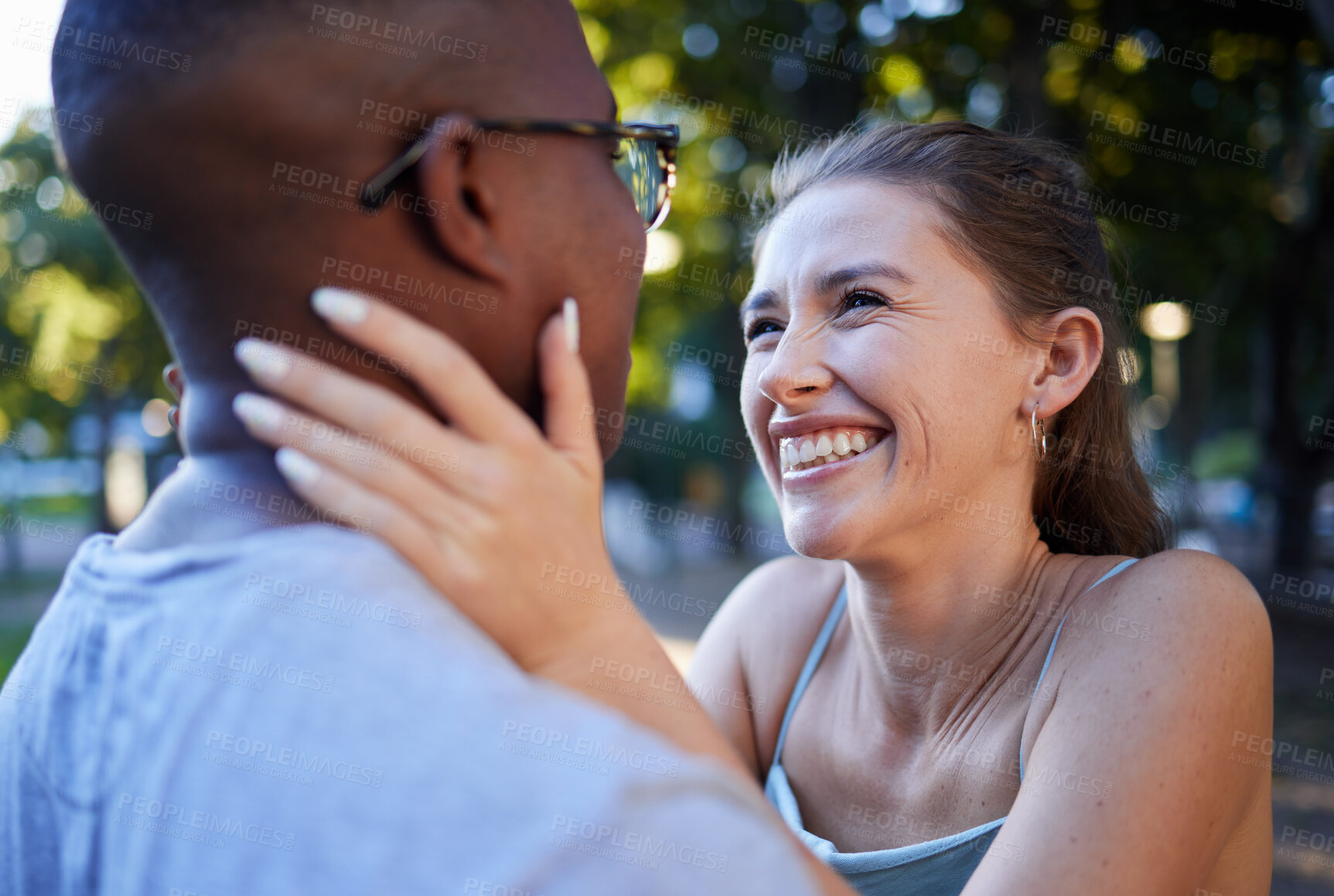 Buy stock photo Love, happy or couple of friends in a park bonding on a romantic date in nature in an interracial relationship. Embrace, funny black man and young woman enjoying quality time on a holiday vacation