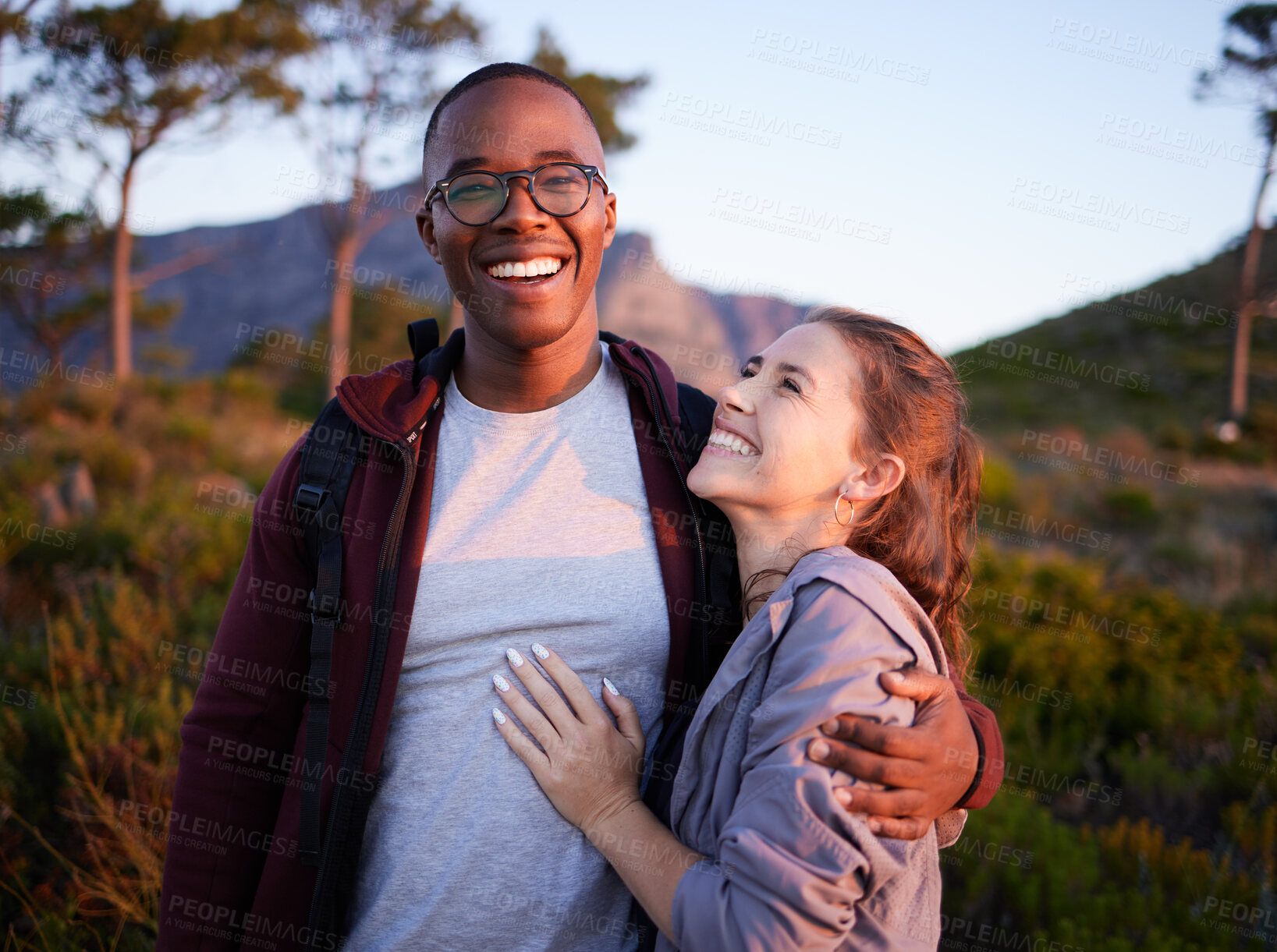 Buy stock photo Smile, nature and portrait of interracial couple on mountain for holiday, vacation and hiking adventure on weekend. Travel, dating and happy man hugging woman enjoy calm, outdoor freedom and peace