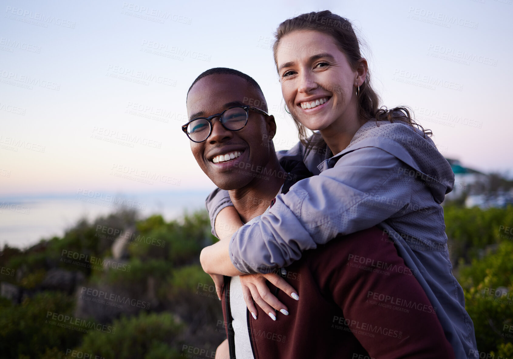 Buy stock photo Love, nature and portrait of interracial couple on mountain for holiday, vacation and adventure on weekend together. Travel, dating and happy man piggyback woman enjoy calm, outdoor freedom and peace