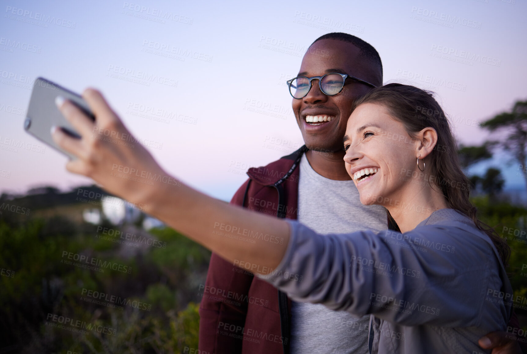 Buy stock photo Interracial couple, phone and smile for selfie, journey or travel adventure or trip together in the nature outdoors. Happy woman holding smartphone with man for photo or social media at a safari