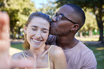 Buy stock photo Love, kiss and selfie with interracial couple at park for relax, social media and romantic date. Support, happiness and quality time with black man and woman in nature for bonding, calm and vacation