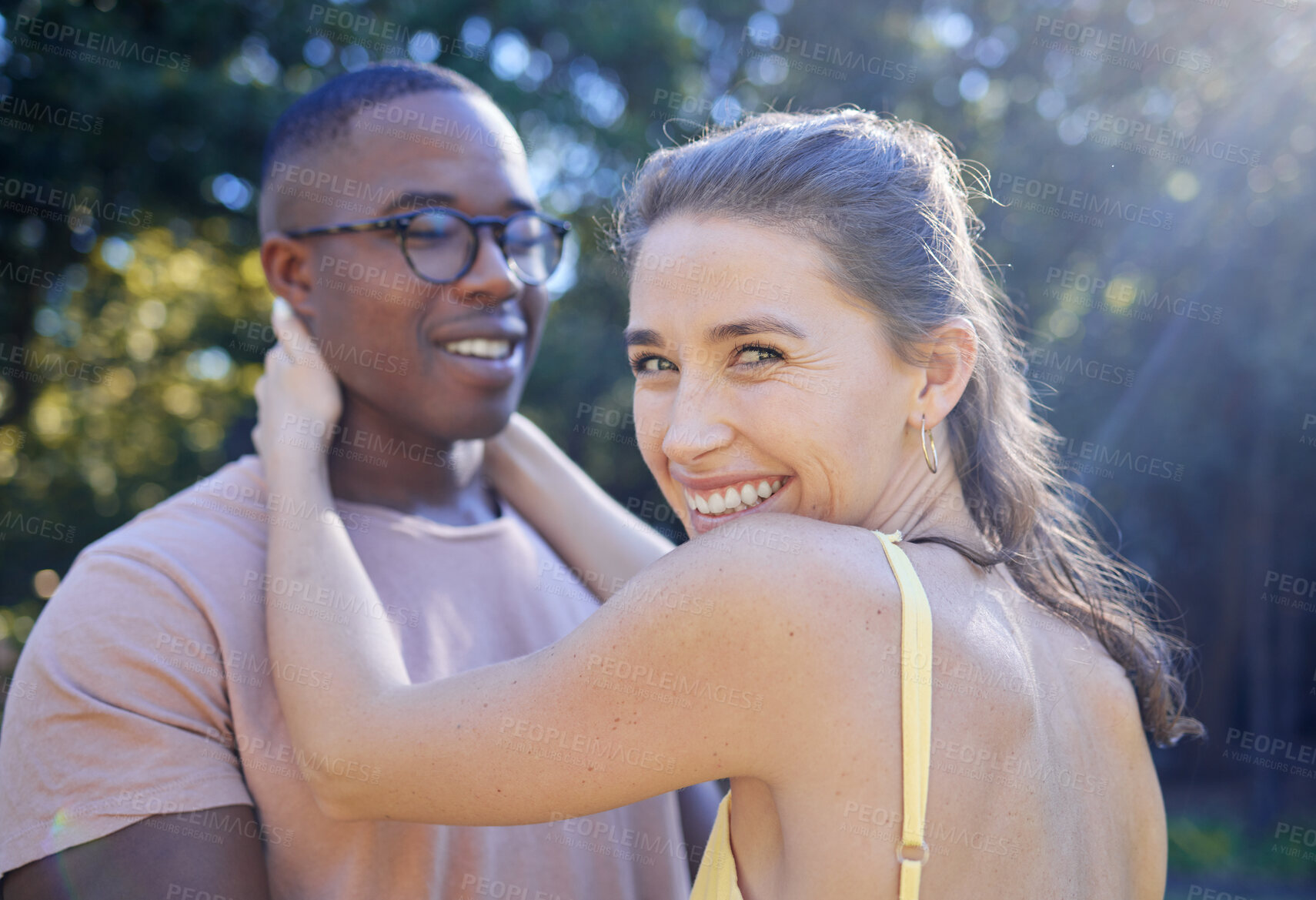 Buy stock photo Happy woman, smile and interracial couple for hug, love or care for summer holiday, relationship or bonding in the park. Female holding man smiling in happiness for quality time, romance or embrace