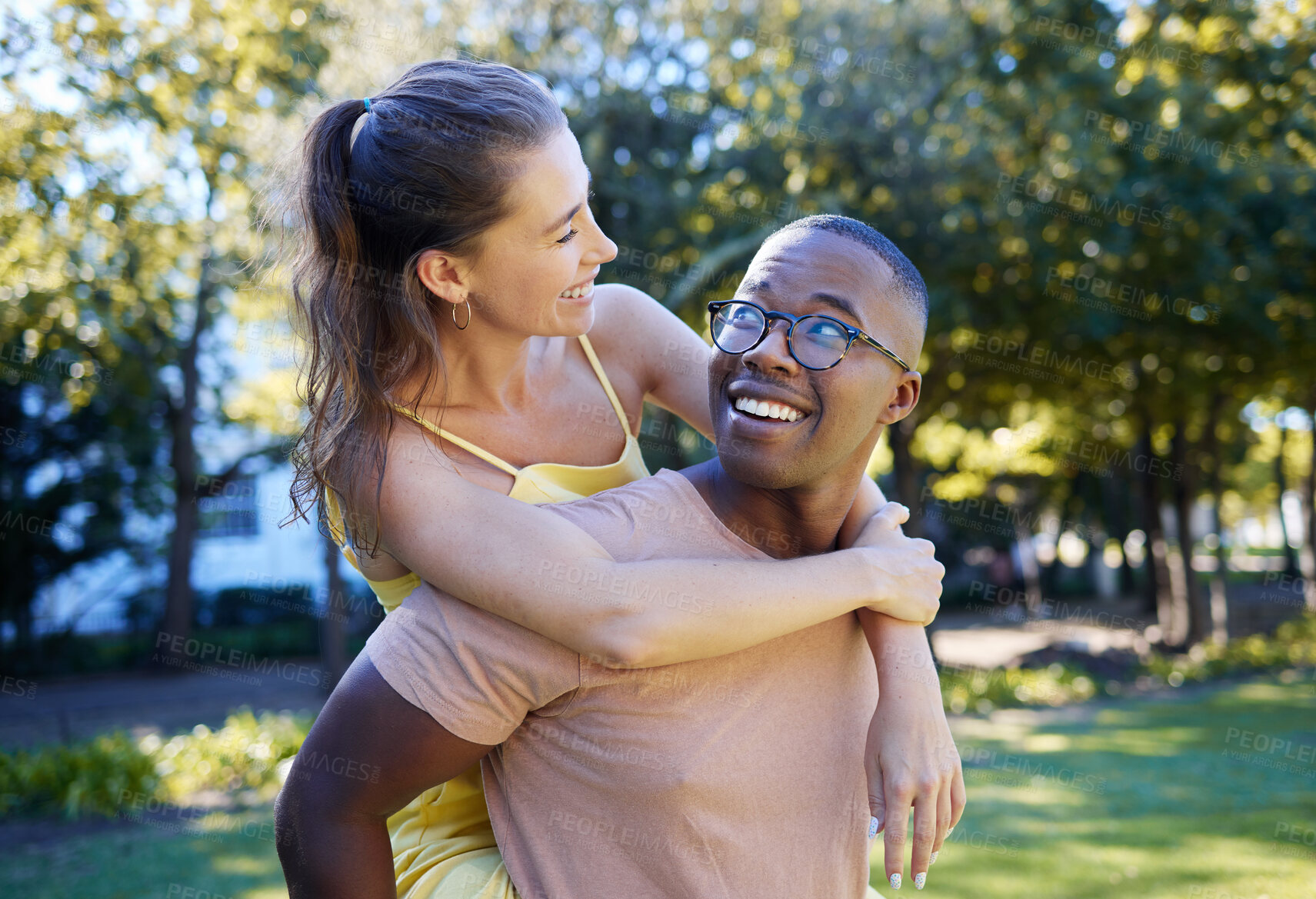 Buy stock photo Interracial couple, care and piggy back of people with support, love and smile in a summer park. Freedom, hug and young man and woman outdoor on date together happy about bonding and dating in nature