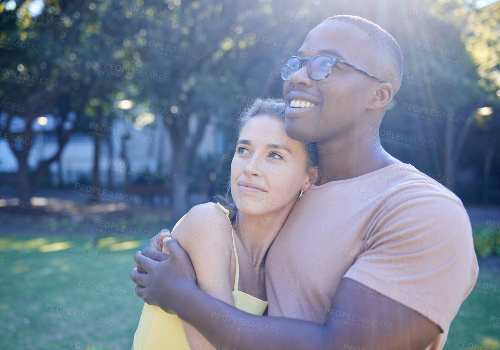 Buy stock photo Interracial couple, hug and park with smile, thinking or love for bonding, together and vision of future. Multicultural relationship, black man and woman for happiness, outdoor and diversity on grass