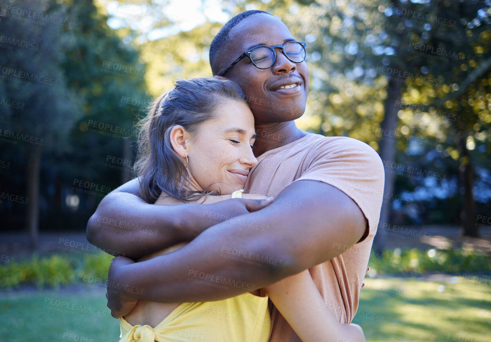 Buy stock photo Black man, interracial couple and hug on park lawn with love, care and bonding for quality time, reunion and happiness. Multicultural embrace, happy relationship and outdoor diversity on adventure