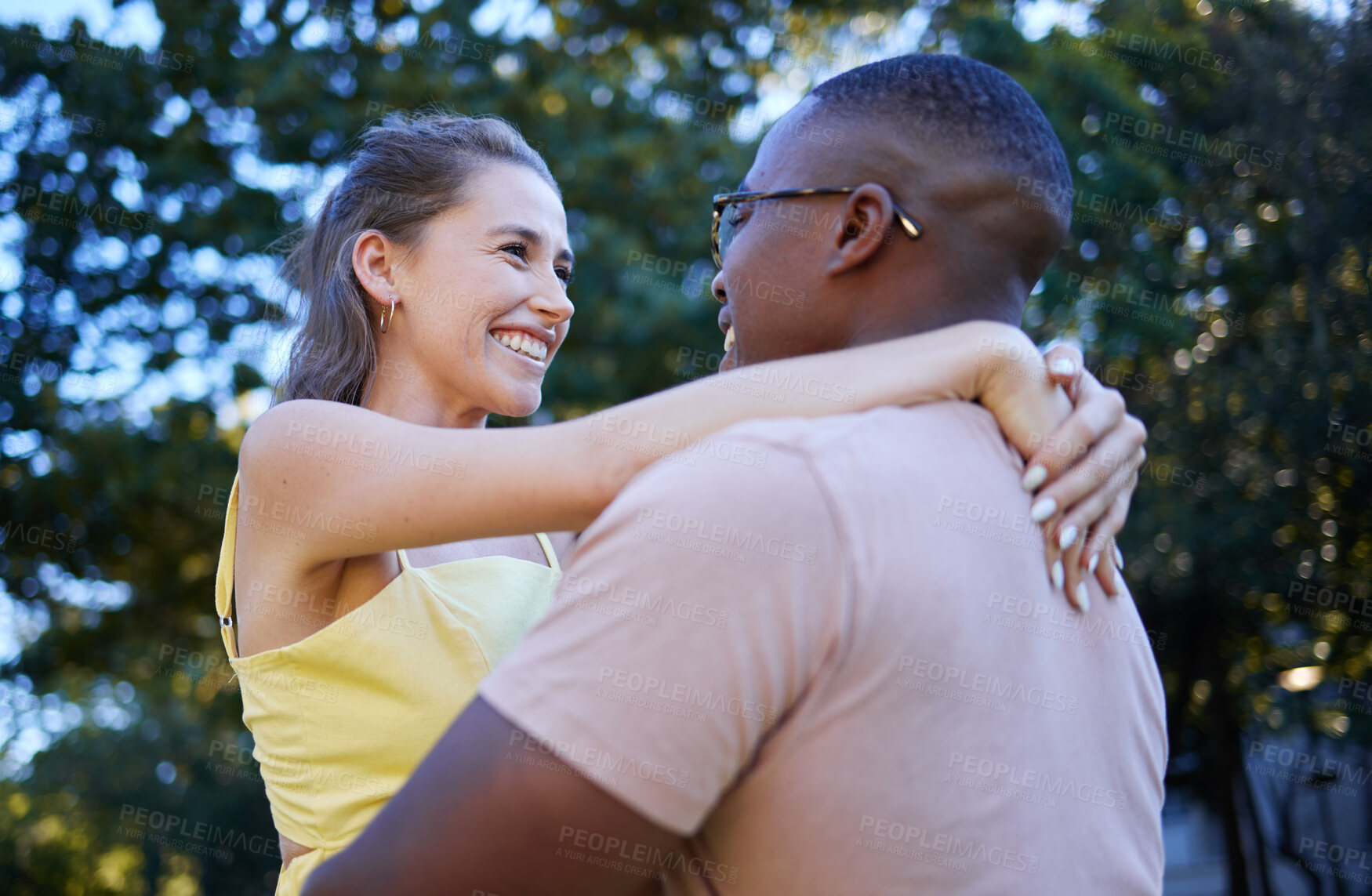 Buy stock photo Interracial couple, smile and hug in romance for love, care or embracing relationship in a nature park. Happy black man hugging woman and smiling in happiness for romantic, embrace or support outside