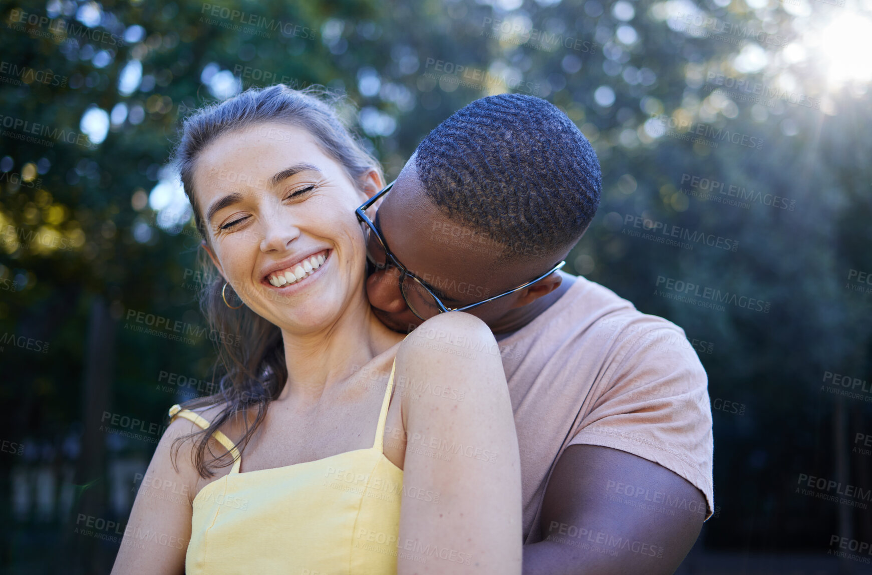 Buy stock photo Love, park and kissing with an interracial couple bonding outdoor together on a romantic date in nature. Summer, romance and diversity with a man and woman dating outside in a green garden