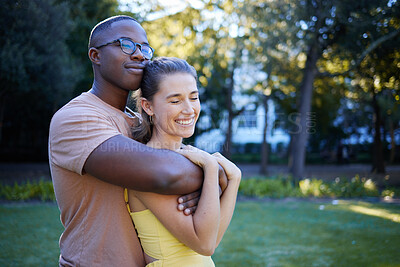 Buy stock photo Summer, love and mockup with an interracial couple bonding outdoor together in a park or garden. Nature, diversity and romance with a man and woman hugging while on a date outside in the countryside