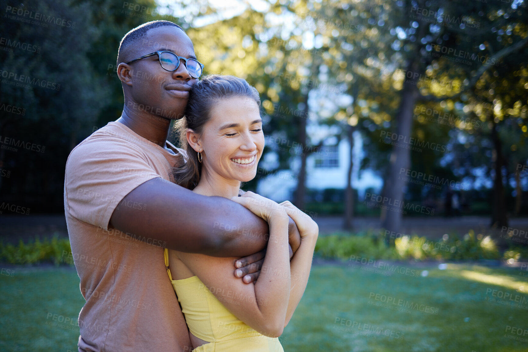 Buy stock photo Summer, love and mockup with an interracial couple bonding outdoor together in a park or garden. Nature, diversity and romance with a man and woman hugging while on a date outside in the countryside