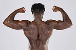 Flexing, muscle and back of a black man with power isolated on a grey studio background. Fitness, sexy and strong body of an African bodybuilder showing biceps from gym exercise on a backdrop