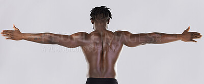 Buy stock photo Back, arms and muscular with a model black man posing in studio on a gray background for fitness or exercise. Muscle, health and wellness with a strong male athlete standing or flexing for power