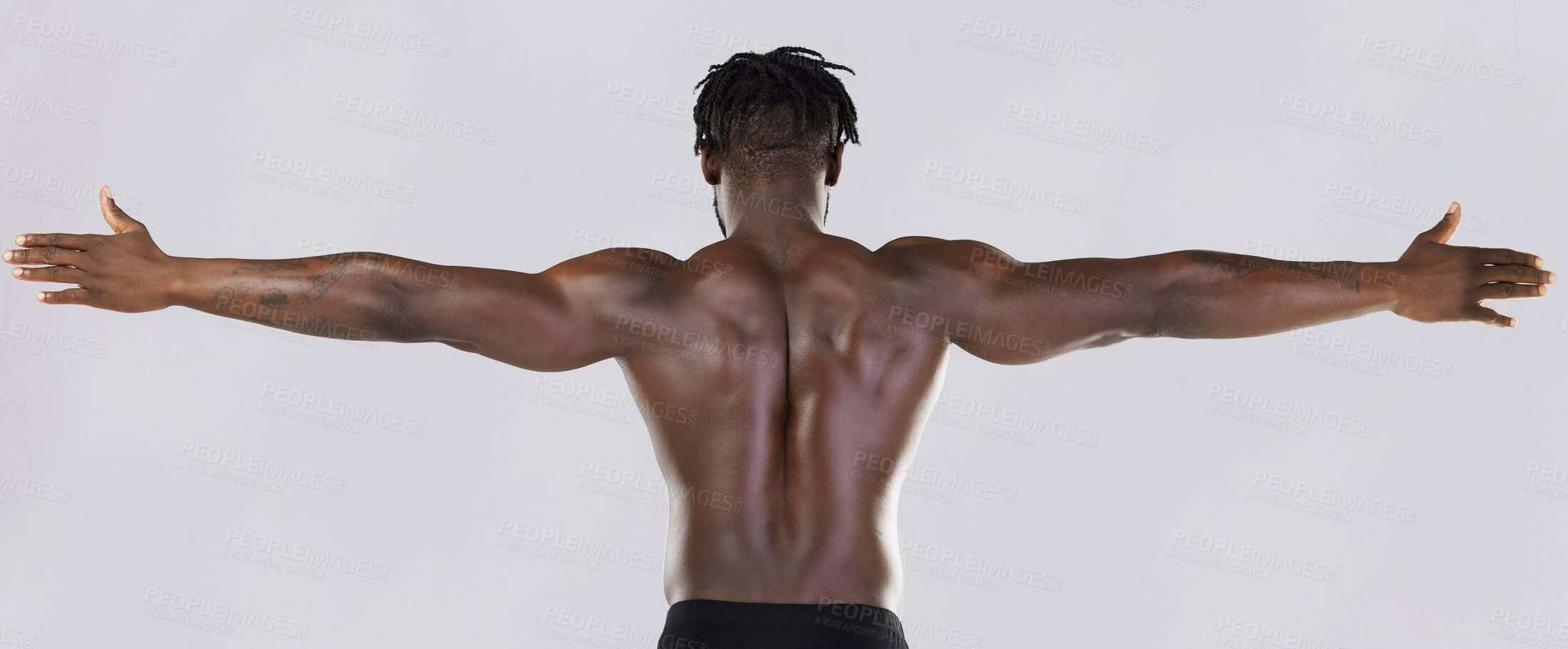 Buy stock photo Back, arms and muscular with a model black man posing in studio on a gray background for fitness or exercise. Muscle, health and wellness with a strong male athlete standing or flexing for power