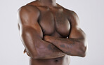Naked body, skin and black man, arms crossed and muscle, strong with fitness isolated on studio background. Muscular, bodybuilder and natural cosmetics, clean and fresh with skincare and nude