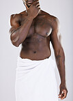 Nude, black man in towel and skin with muscle, shower and hygiene, grooming and beauty isolated on studio background. Abs, fitness and strong male, skincare glow and body care with natural cosmetics