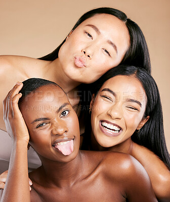 Buy stock photo Diversity, beauty and women in crazy portrait smile together, skincare friends on studio background. Health, wellness and luxury cosmetics for beautiful multicultural people in makeup with tongue out