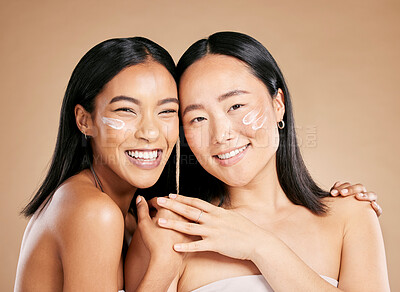 Buy stock photo Portrait, cream and diversity with model woman friends in studio on a beige background for skincare. Face, natural and wellness with a young female and friend posing to promote a cosmetic product