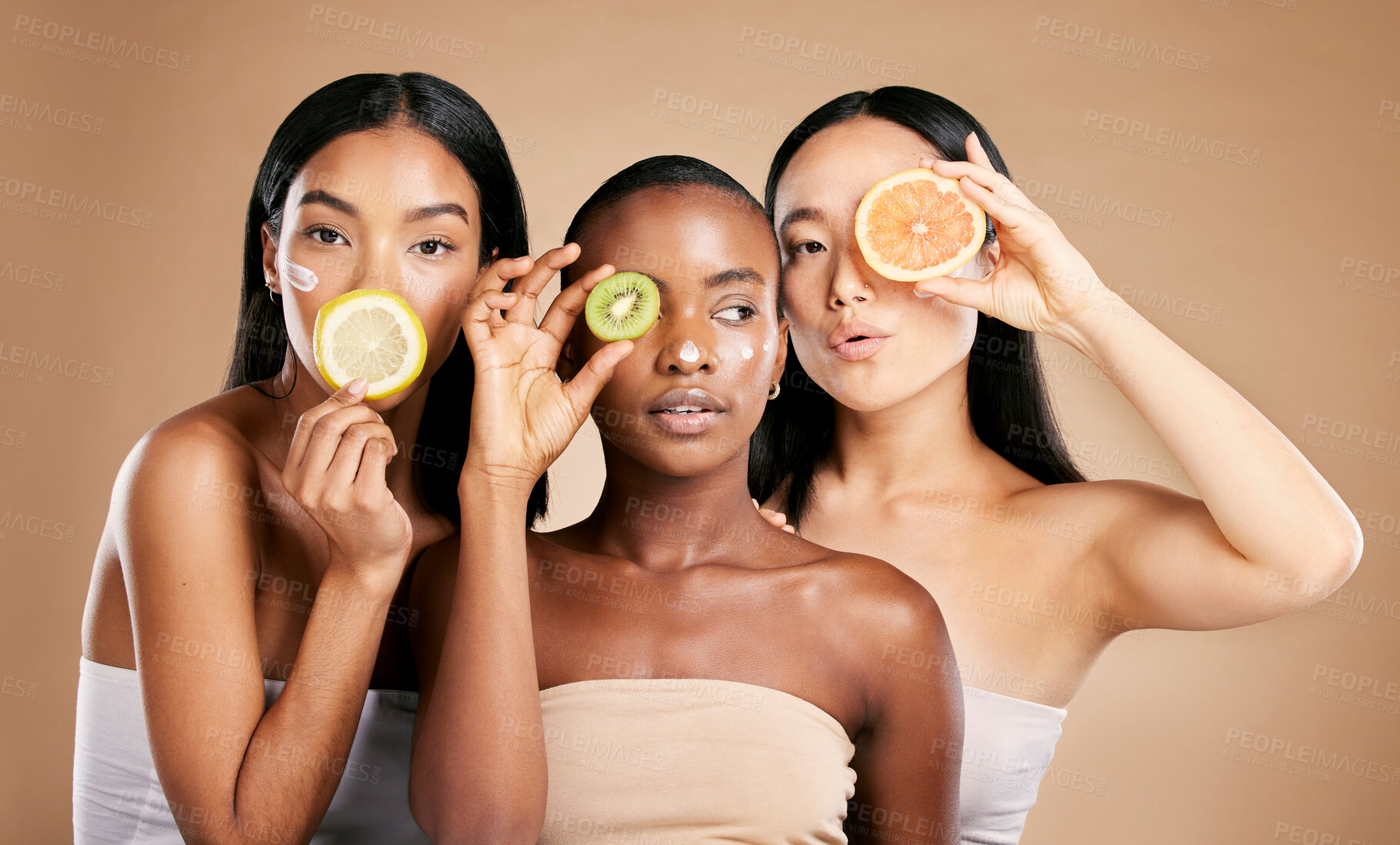 Buy stock photo Skincare, diversity and women with fruit, cosmetics and dermatology with friends on brown studio background. Face, vitamin c or ladies with natural beauty, girls and nutrition with healthy lifestyle 