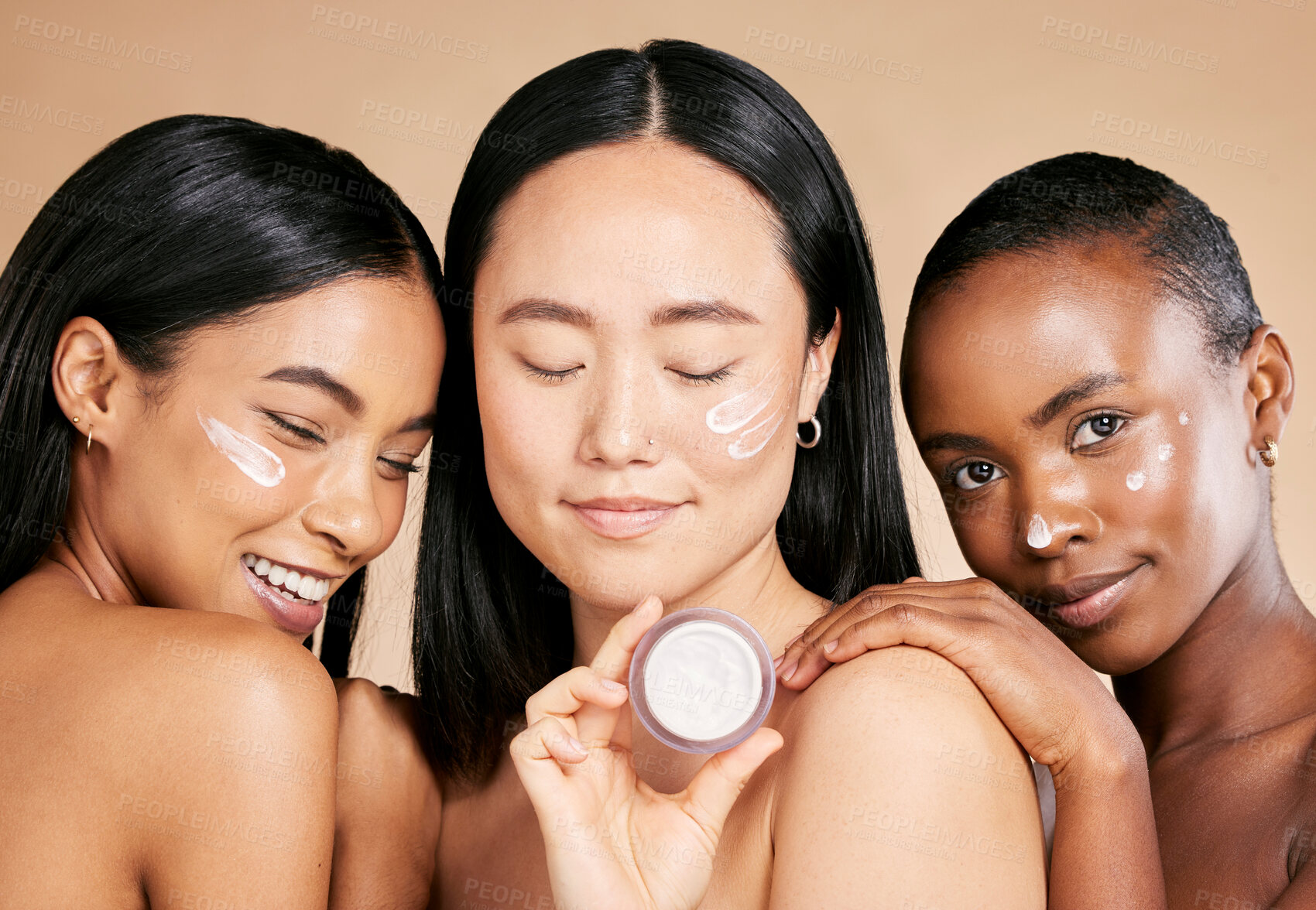 Buy stock photo Diversity, face and cream product by women in studio for skincare, wellness and grooming on brown background. Beauty, different and friends by girl group relax with facial, mask and skin treatment