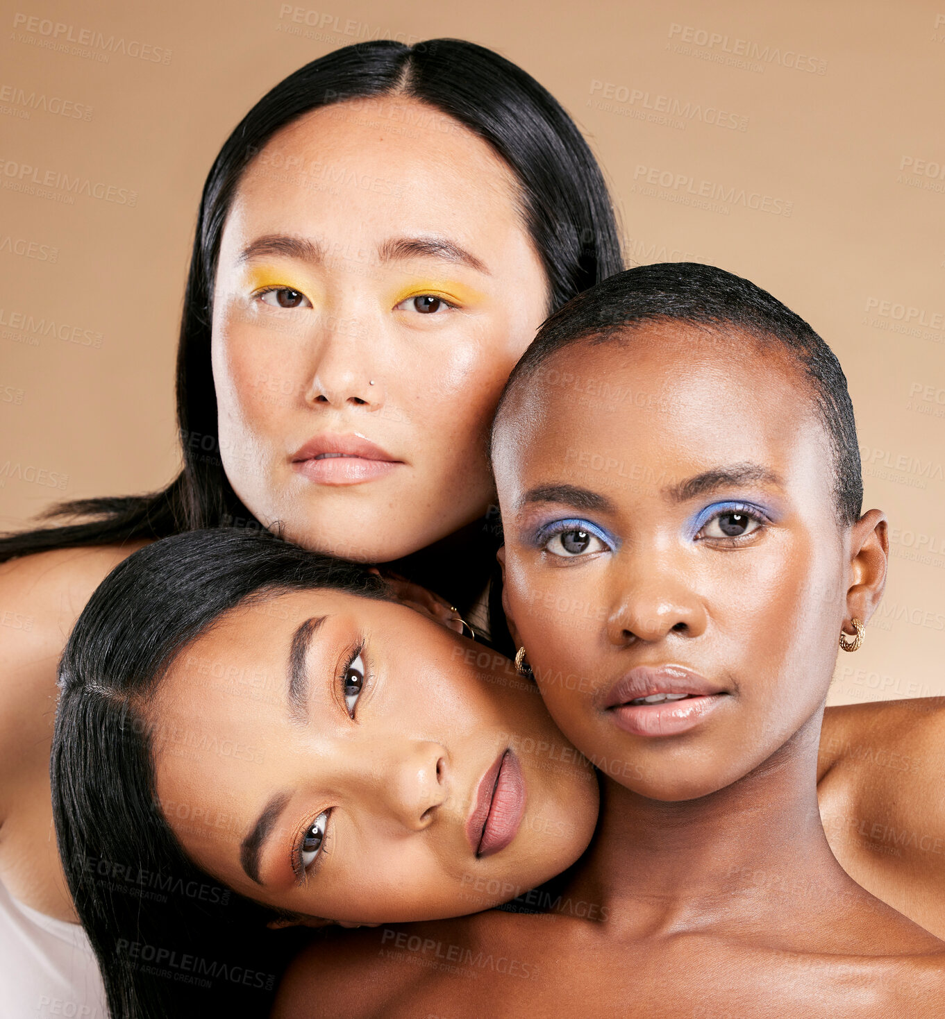 Buy stock photo Diversity, woman and focus face with makeup, skincare beauty and cosmetics dermatology in brown background studio. Interracial models, facial care and support together for natural glowing skin  
