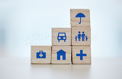 Buy stock photo Building blocks of medical, house and life insurance cover on blurred background for family, safety and healthcare icon. Goals, risk management and car, home and umbrella sign on wood for services