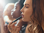 Makeup, lipstick and woman with in bathroom of nightclub, gen z friends getting ready for party or music concert. Cosmetics, diversity and women backstage at theater, fashion show or dark night club.