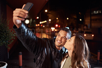 Buy stock photo People, phone and night selfie kiss on cheek on city street, social media or profile picture in birthday celebration vlog. Happy smile, bonding or couple of friends on mobile photography tech in dark