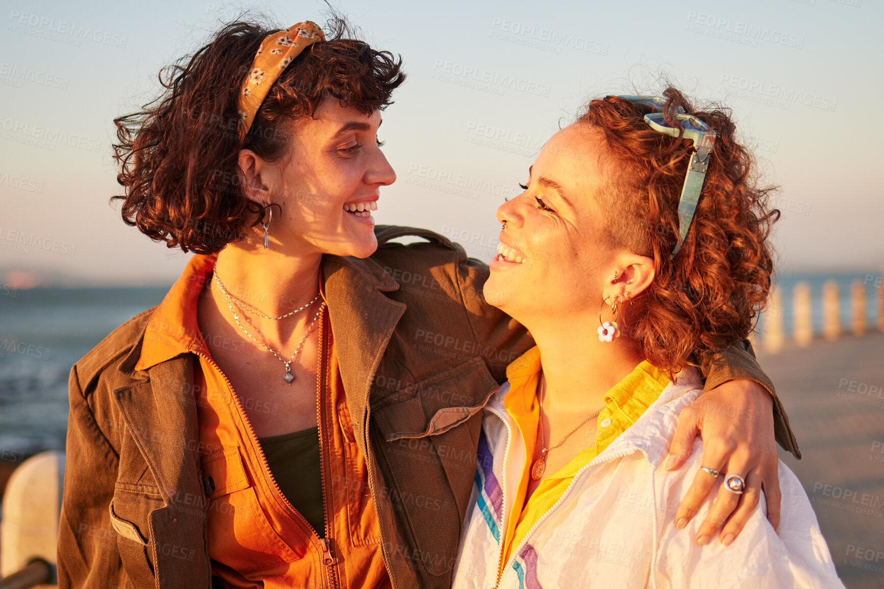 Buy stock photo Lesbian, lgbtq and couple of friends at the beach with love, hug and excited for summer holiday and date. Sunset, sea and smile of women or gay people with pride, freedom and gen z solidarity in sun