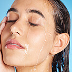 Woman face, water drops and beauty of a person with skincare and peace isolated. Calm, cleaning and healthy young female doing morning self face for skin glow and wellness with blue studio background