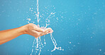 Cleaning, save and hands with water for hygiene, grooming and washing body on a blue background. Shower, beauty and person saving liquid for health, wellness and mockup space on a studio backdrop