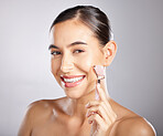 Face roller, happy and woman portrait of skincare with model relax from facial spa treatment. Isolated, studio background and young person busy with dermatology, self care and beauty for skin