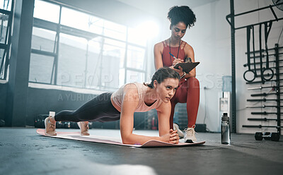 Buy stock photo Personal trainer, fitness and clipboard with a black woman coaching a client in a gym during her workout. Health, exercise or training and a female athlete doing a plank with her coach writing notes