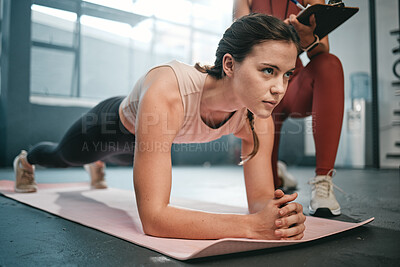 Fitness, plank and personal trainer with a sports woman training in a gym for strong core muscles. Teamwork, motivation or exercise with a female athlete and her coach during a workout for health