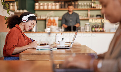 Buy stock photo Woman, student and studying in cafe, laptop and make notes for exams, smile and concentration for test. Young female, lady or academic with headphones, podcast or writing audio to text in coffee shop