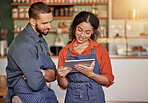 Restaurant, cafe teamwork and couple with tablet to manage orders, inventory and stock check. Diversity, waiter technology and man and woman with digital touchscreen for managing sales in coffee shop