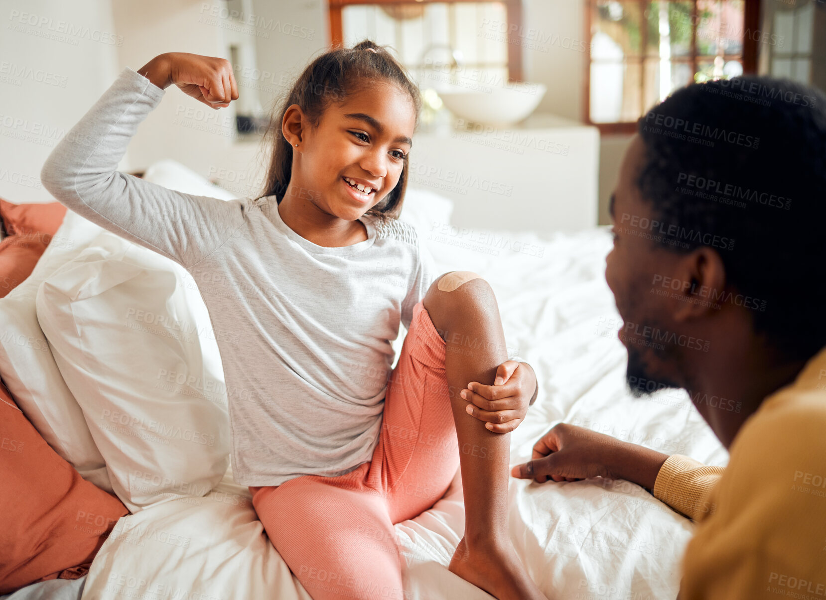 Buy stock photo Family, bed and father with girl and band aid show muscles, brave and strong gesture for injury. Love, home and happy dad helping child with plaster for first aid care, wound and hurt knee in bedroom