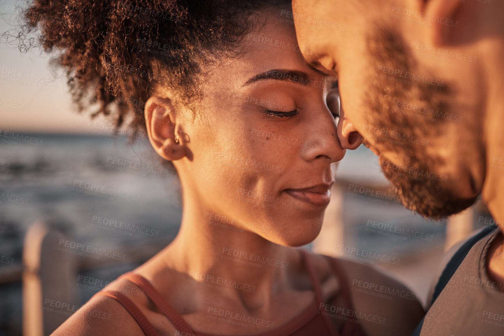 Buy stock photo Black couple, hug and touching forehead embracing relationship, compassion or love and care by the beach. Happy man and woman with heads together smiling in happiness for support, trust or romance