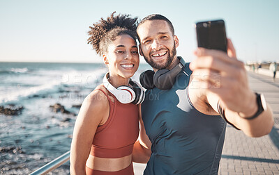 Buy stock photo Fitness, couple and phone with smile for selfie, running exercise or workout in the outdoors. Happy man and woman smiling in happiness looking at smartphone for photo after run by the ocean coast