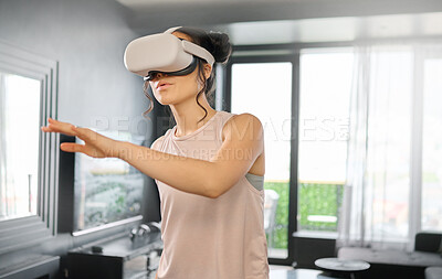Buy stock photo Virtual reality, metaverse and technology with a woman in the living room of her home using a headset to access a 3d game. Futuristic, VR and gaming with a female gamer using ai to play games