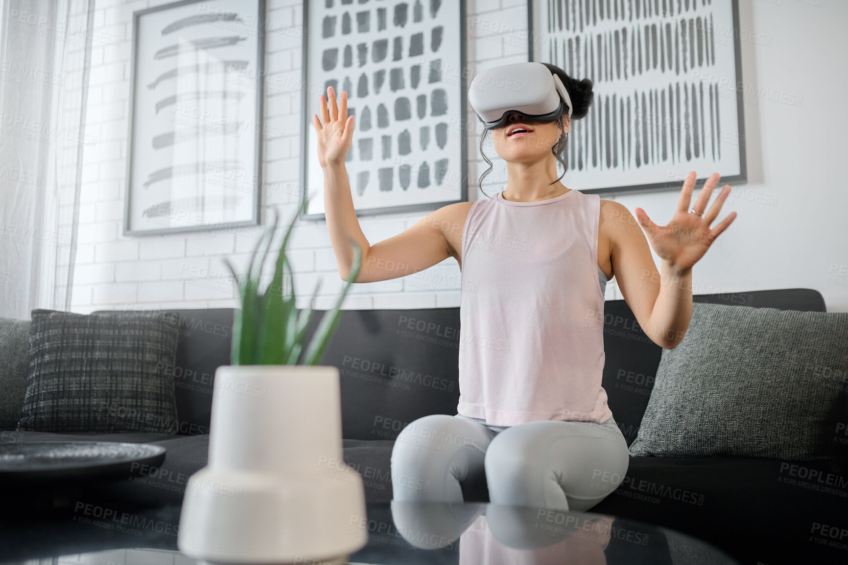Buy stock photo VR, metaverse and technology with a woman in the living room of her home using a headset to access a 3d game. Futuristic, virtual reality and gaming with a female gamer using ai to access games